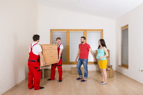 Commercial moving service preparing office furniture for transport in Merton